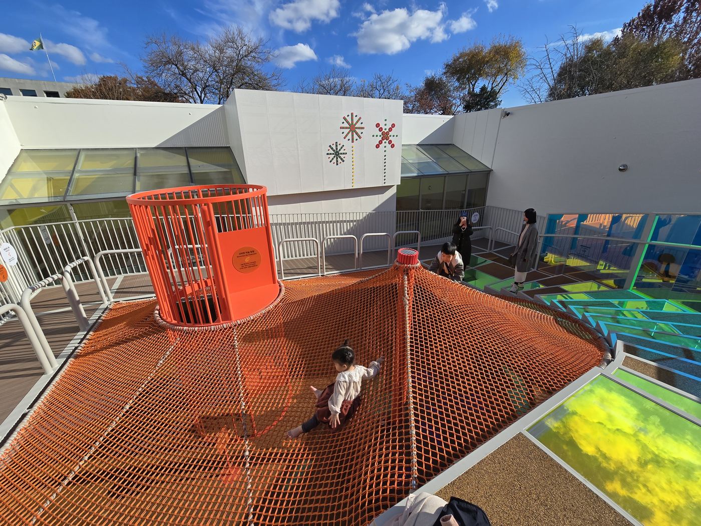 children on orange rope net adventure climbing structure at National Folk Museum
