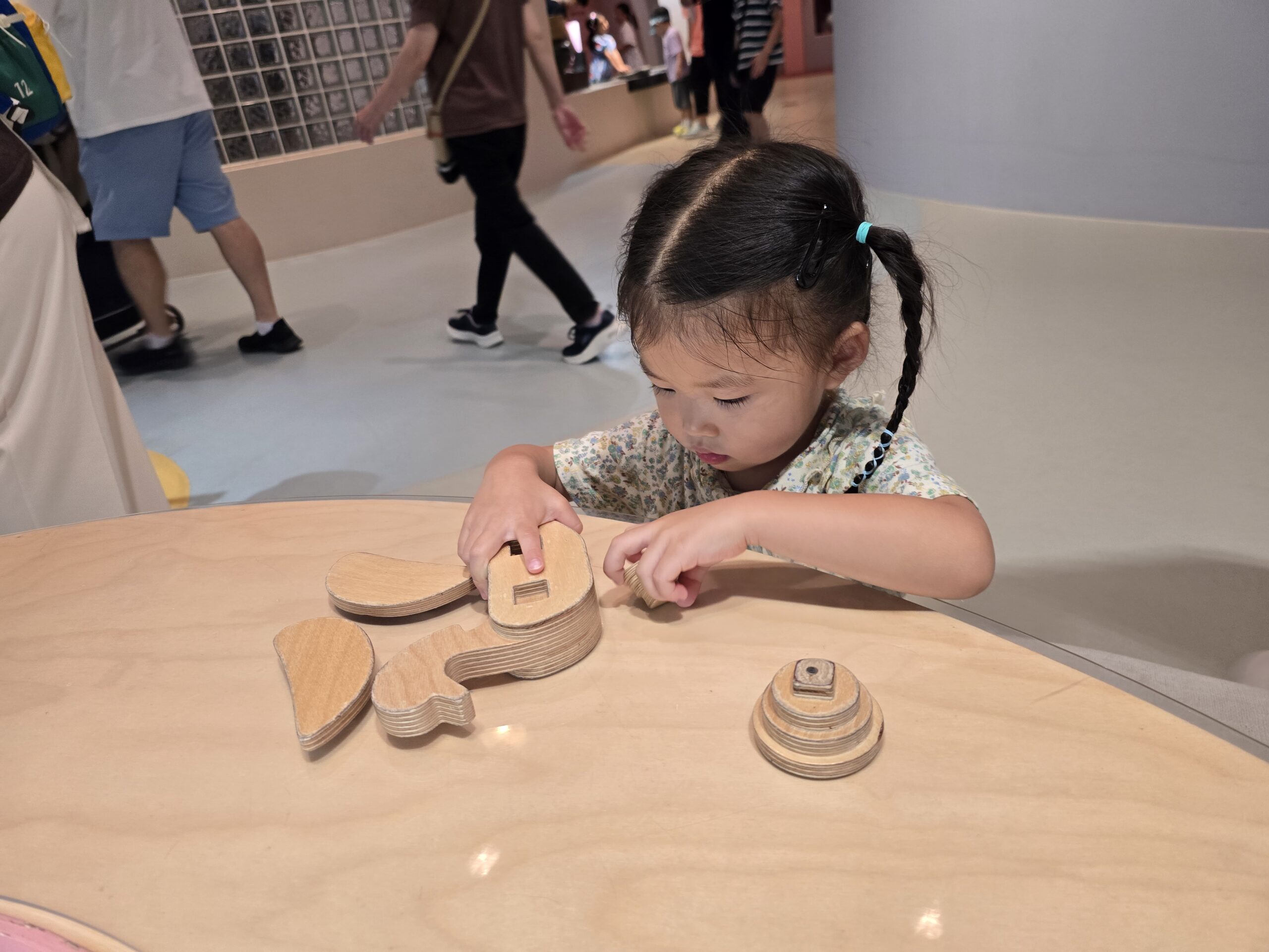 Toddler playing with wooden puzzle activity