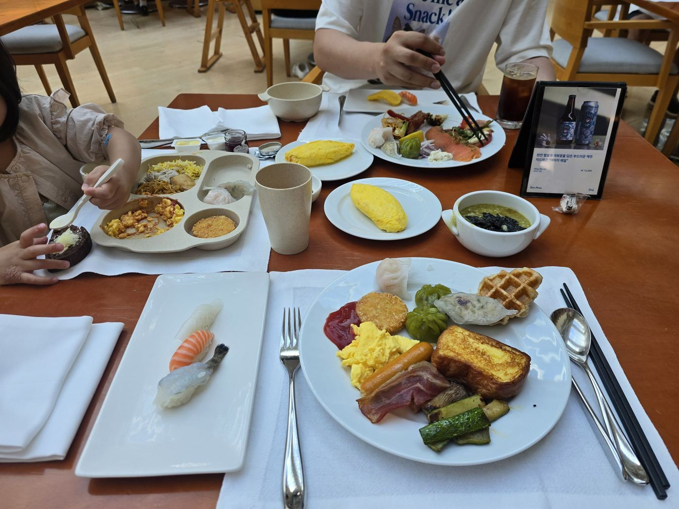 Full breakfast plate — salmon sushi, waffle, omelette, French toast