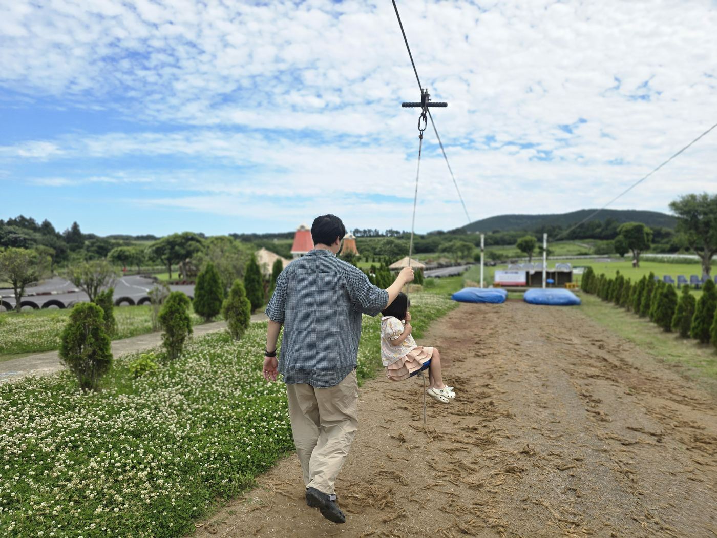 Parent pushing child on zipline at Dreukumda