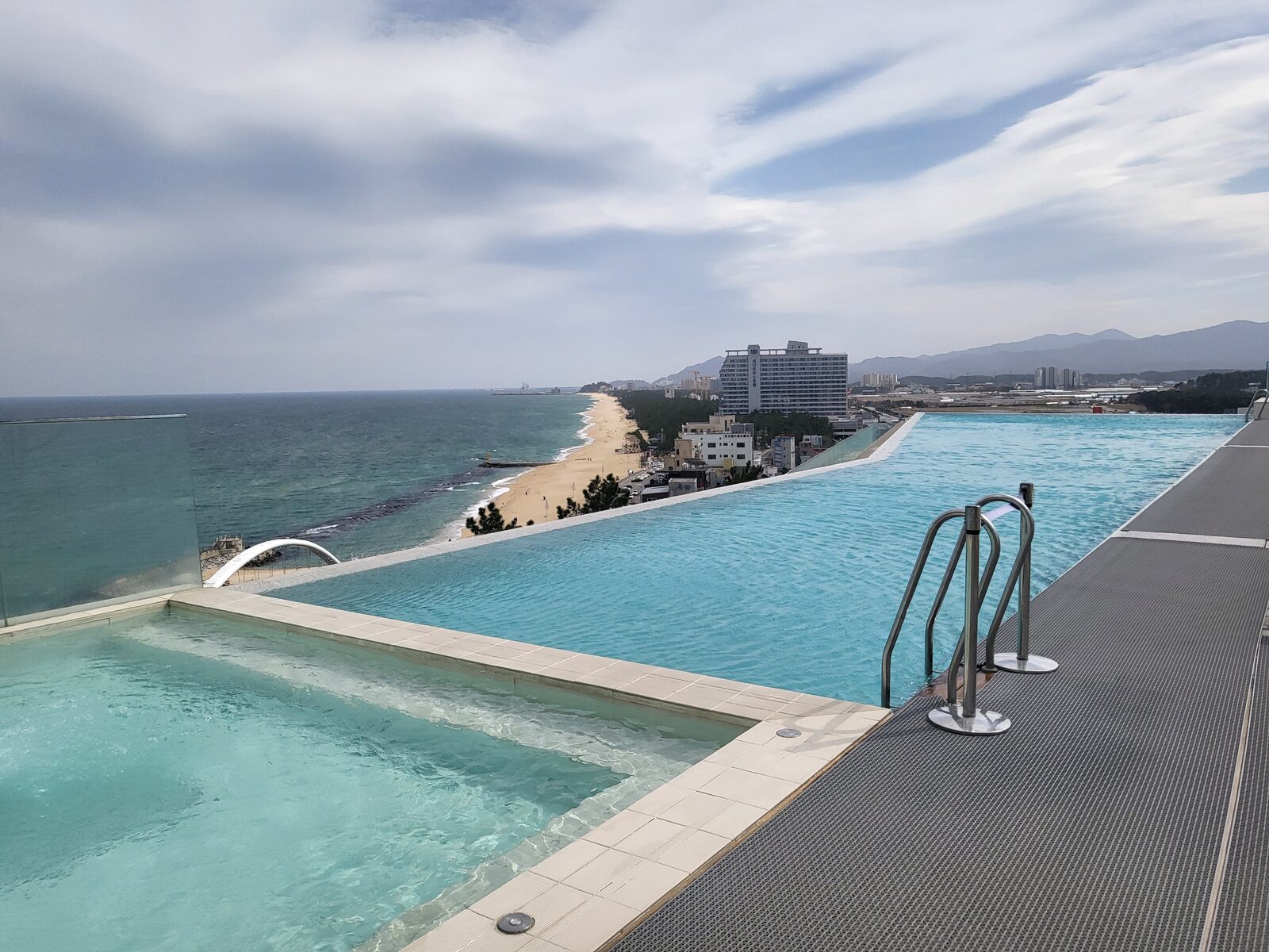 Outdoor infinity pool at SEAMARQ Hotel Gangneung merging with the ocean and Anmok Beach