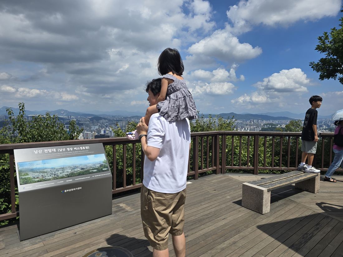 Father and child looking at the Seoul skyline from Namsan