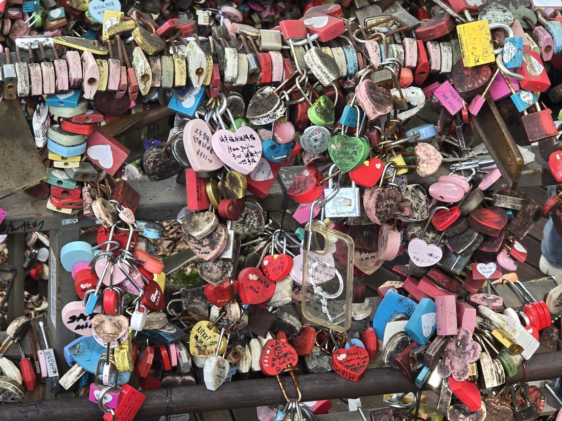 Close-up of heart-shaped love locks with handwritten messages