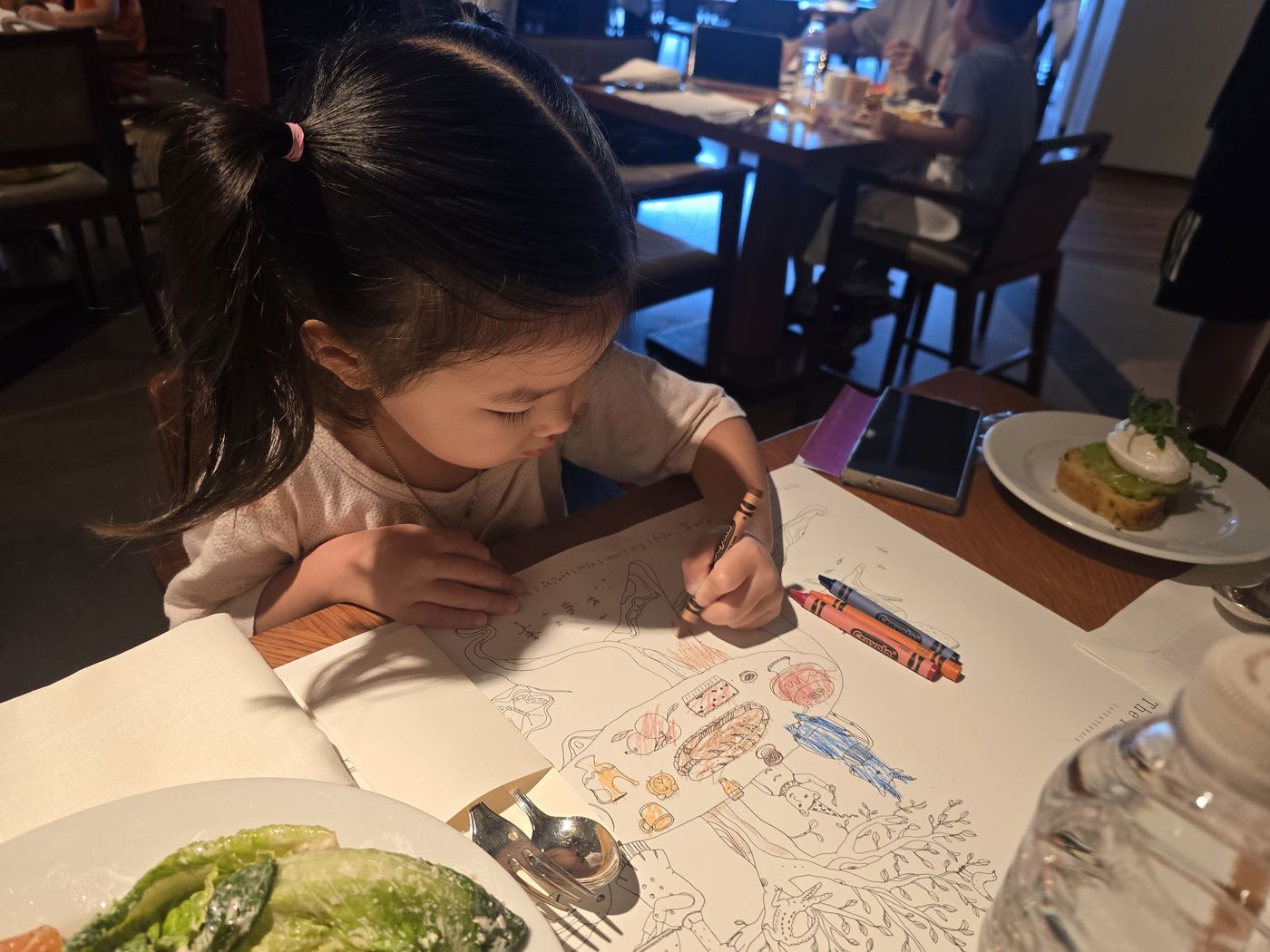 Child's table setting with coloring set at breakfast